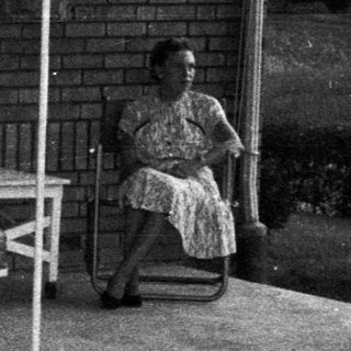 Black and white image of a porch with furniture.