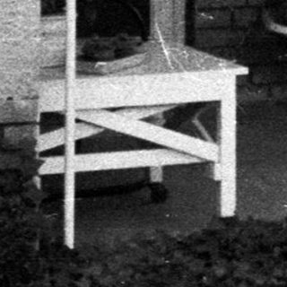 Black and white image of a porch with furniture.