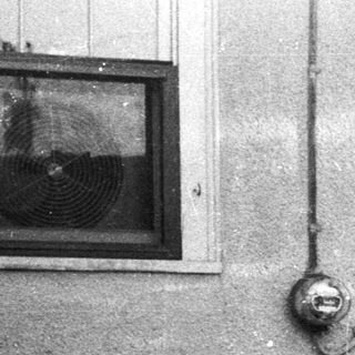 Black and white image of a porch with furniture.