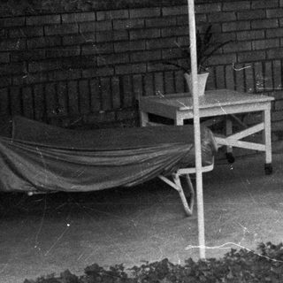 Man seated on porch, relaxing in a vintage setting.