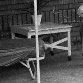 Man seated on porch, relaxing in a vintage setting.