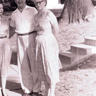 Here's a brief summary of the image: Couple and woman walking on a path outdoors.