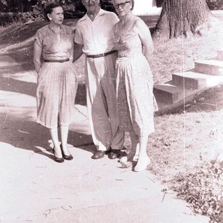Here's a brief summary of the image: Couple and woman walking on a path outdoors.