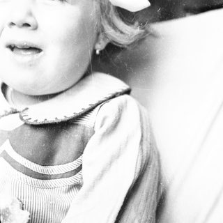Black and white portrait of a young child with fair hair.