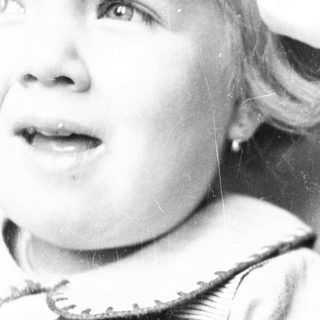 Black and white portrait of a young child with fair hair.