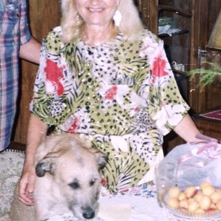 Couple and dog near a table with food and decor.