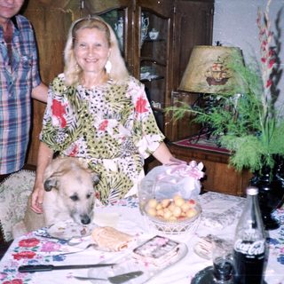 Couple and dog near a table with food and decor.