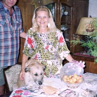 Couple and dog near a table with food and decor.