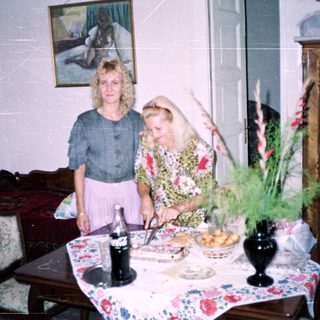 Two women standing near a table with food and decor.