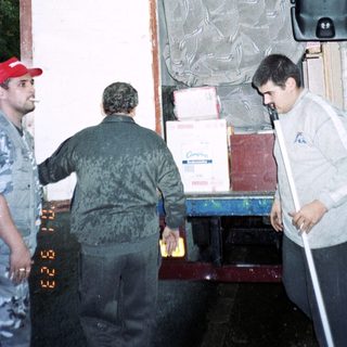 Men loading boxes and items onto a truck.