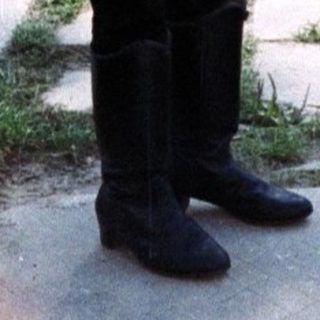 Boy stands outdoors next to a utility pole.