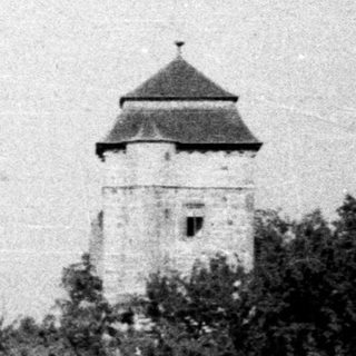 Black and white photo of a tower on a hill.