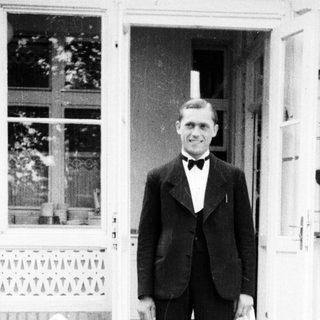 Man in a suit stands outside a building.