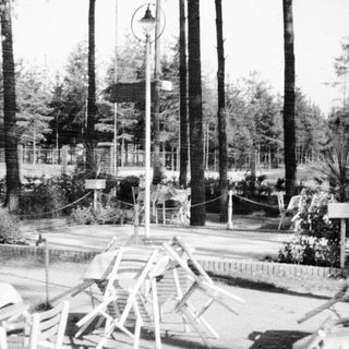 Collapsed chairs and debris amid trees and a park.