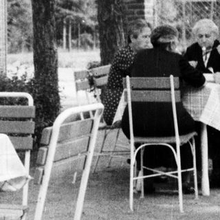 Black and white photo of a waiter at an outdoor cafe.