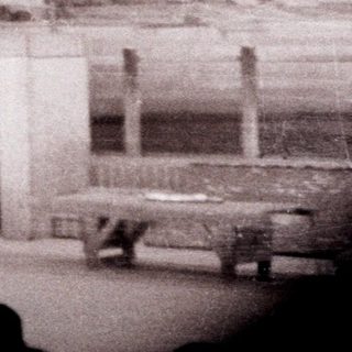 Stage set depicting a building with a person standing before it.