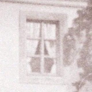 Stage set depicting a building with a person standing before it.