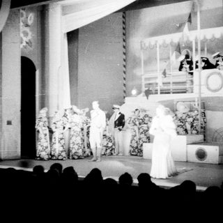 Stage performance with people in costumes and uniforms.