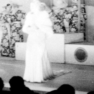 Stage performance with people in costumes and uniforms.