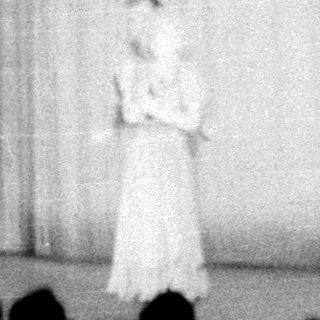 Stage scene featuring a performer and ornate backdrop.