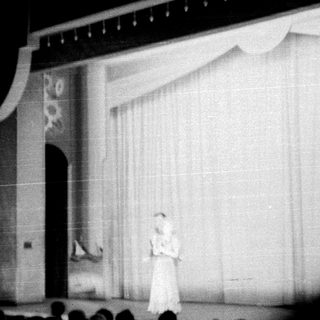 Stage scene featuring a performer and ornate backdrop.