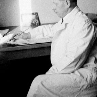 Man seated at a desk, appearing to be writing.