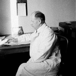 Man seated at a desk, appearing to be writing.