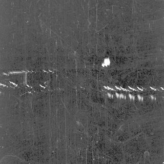 Nighttime view of a road with vehicle headlights.
