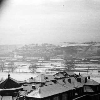 Snow-covered rooftops overlooking a winter industrial landscape.