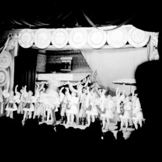 A group of performers on a stage, possibly dancers.