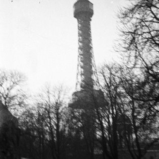 Black and white image of a tall tower in winter.