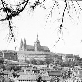 Black and white image of Prague Castle overlooking a town.
