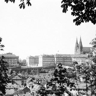 Black and white cityscape with buildings and a cathedral.