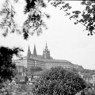 Black and white photo of Prague Castle with surrounding buildings.