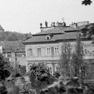 Black and white photo of Prague Castle with surrounding buildings.