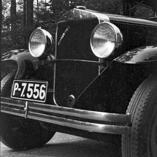 Black and white photo of a vintage car's front.