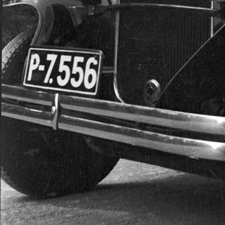 Black and white photo of a vintage car's front.