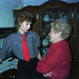 Three people standing indoors, likely engaged in conversation.