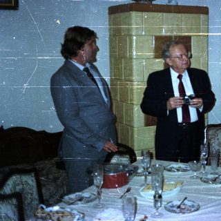 Group conversing near a table set for a meal.