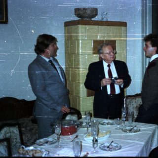 Group conversing near a table set for a meal.