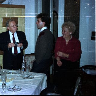 Group conversing near a table set for a meal.