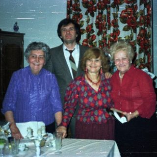 Group portrait of four people in a vintage dining room.