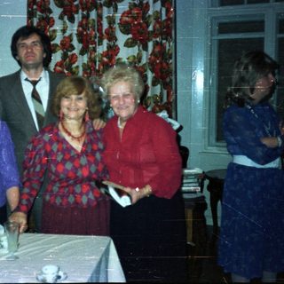 Group portrait of four people in a vintage dining room.
