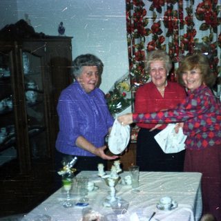 Four women gathered around a table with decorations.