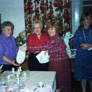 Four women gathered around a table with decorations.