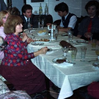 Family dining at a table with a dog present.