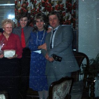 Group of people celebrating, with a dog and table setting.