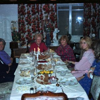 Family seated at a lavishly set dinner table.