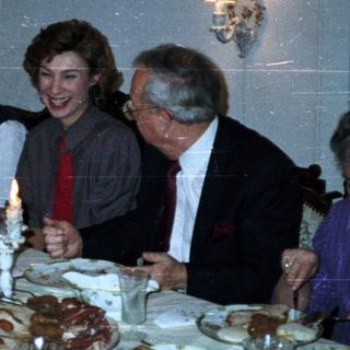 Family gathered around a large table enjoying a meal.