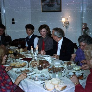 Family gathered around a large table enjoying a meal.